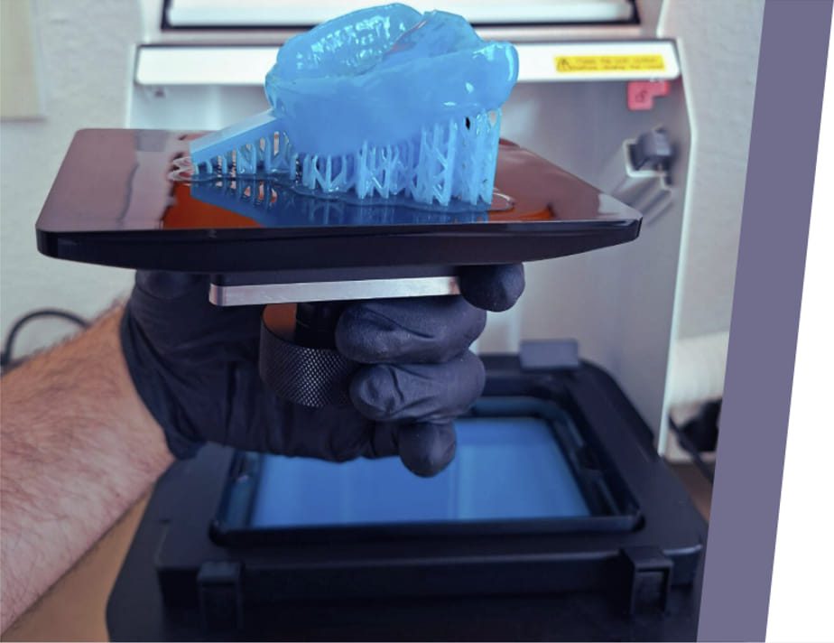 Mano con guante sujetando protesis dental